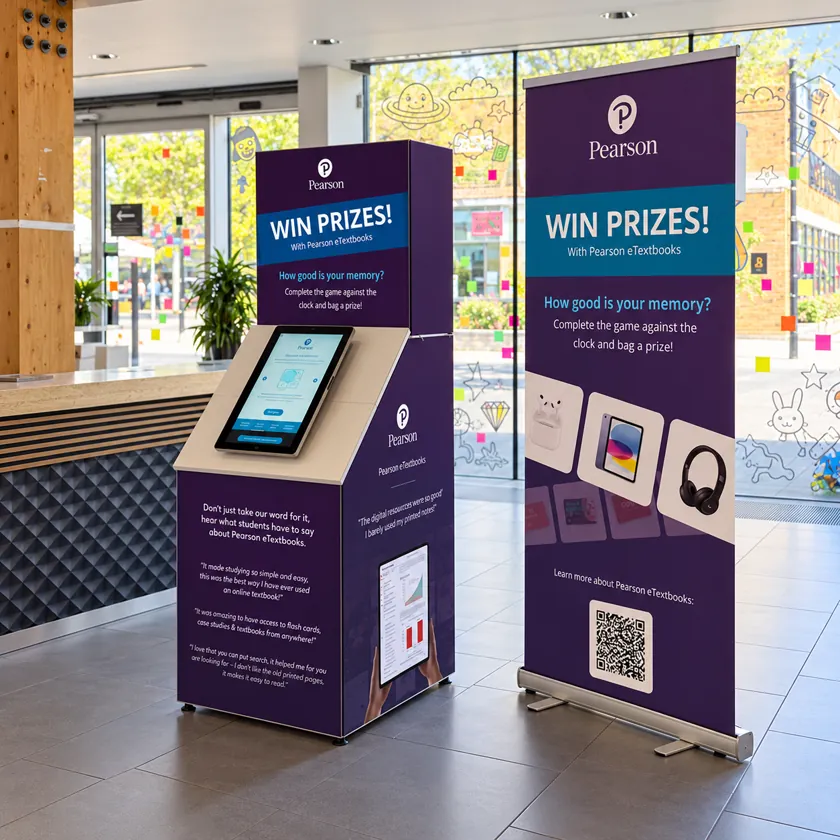 Purple branded kiosk with a Win prizes header and an angled touchscreen, set against a wall of shelves